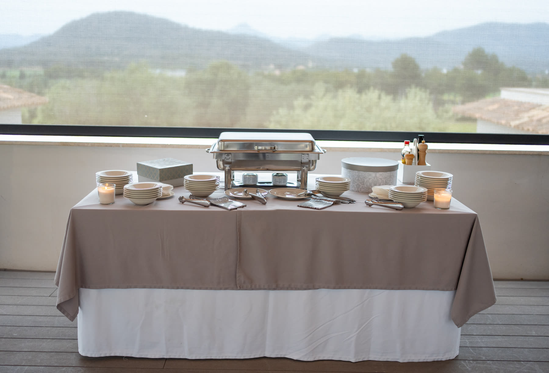 Vorbereitetes Buffet mit Geschirr und Warmhaltestationen